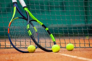 Tennis balls and two racquets on tennis court